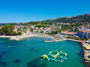 An aerial view of a coastal town with a beach, a water park, and residential buildings. - Cosy apartment for 4 guests with WIFI, A/C, pool, TV, terrace and pets allowed (Senj)