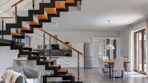 Ein modernes Interieur mit Treppe, Essbereich und Küche.