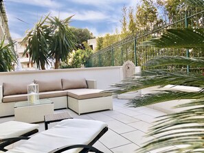 Une terrasse sur le toit aménagée avec un canapé d’angle, des fauteuils et une lanterne décorative.