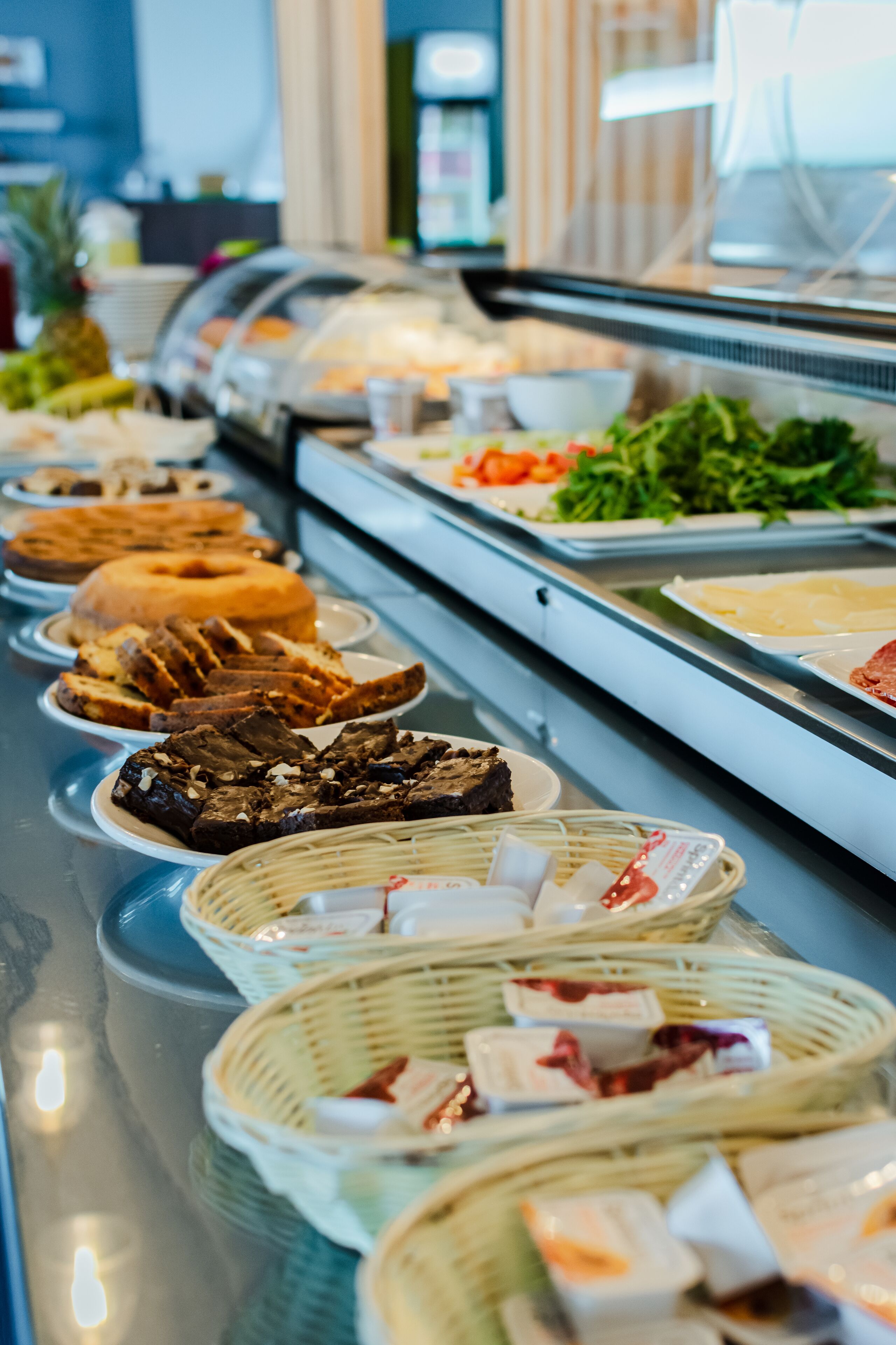 A buffet with various food items including bread, pastries, and salads.