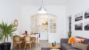 Una sala de estar moderna con comedor, un sofá gris y una mesa de comedor con sillas.