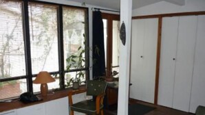A room with a desk, two chairs, a lamp, and a window with blinds. - Paris 20 Pere Lachaise: VERY QUIET STUDIO WITH A TERRACE (Paris)