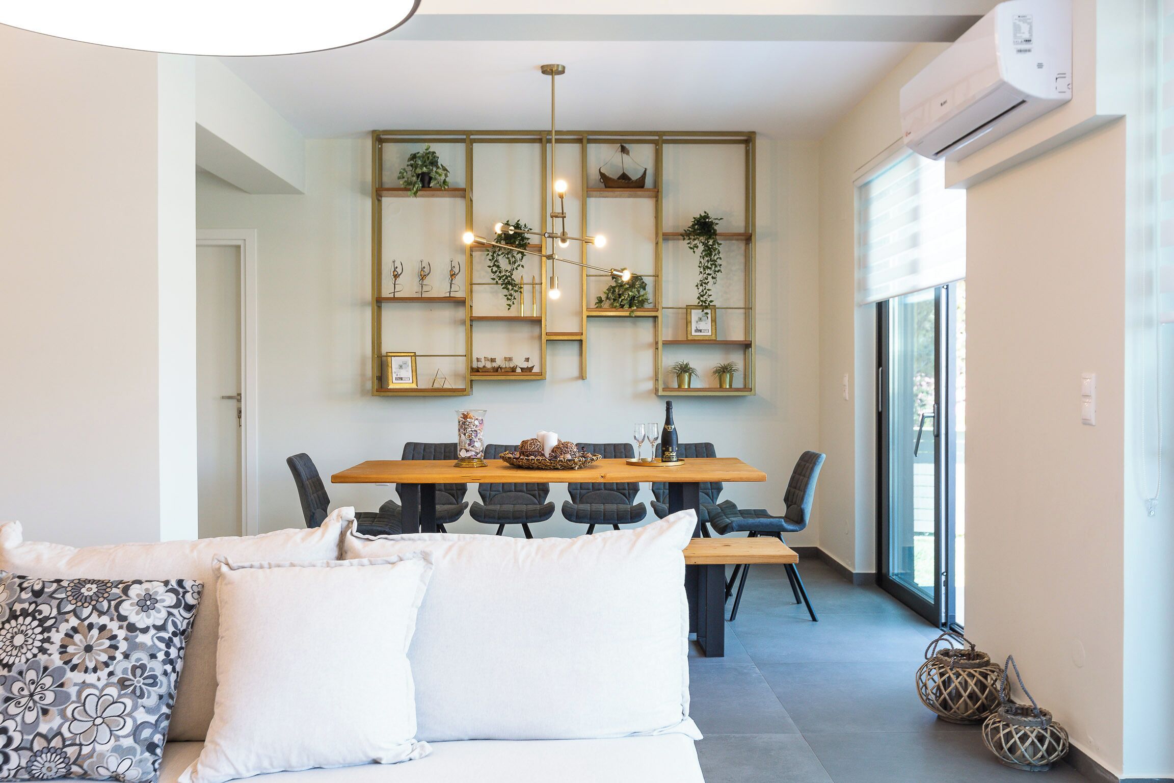 A modern dining area with a wooden table, chairs, and a decorative wall with plants.