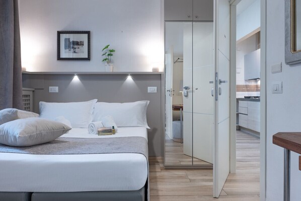 2 habitaciones, escritorio y tabla de planchar con plancha