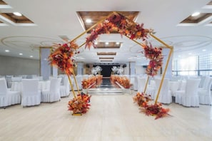 A venue with a central aisle, white chairs, and a floral archway. - Eerguna Hotel (EERGUNA)
