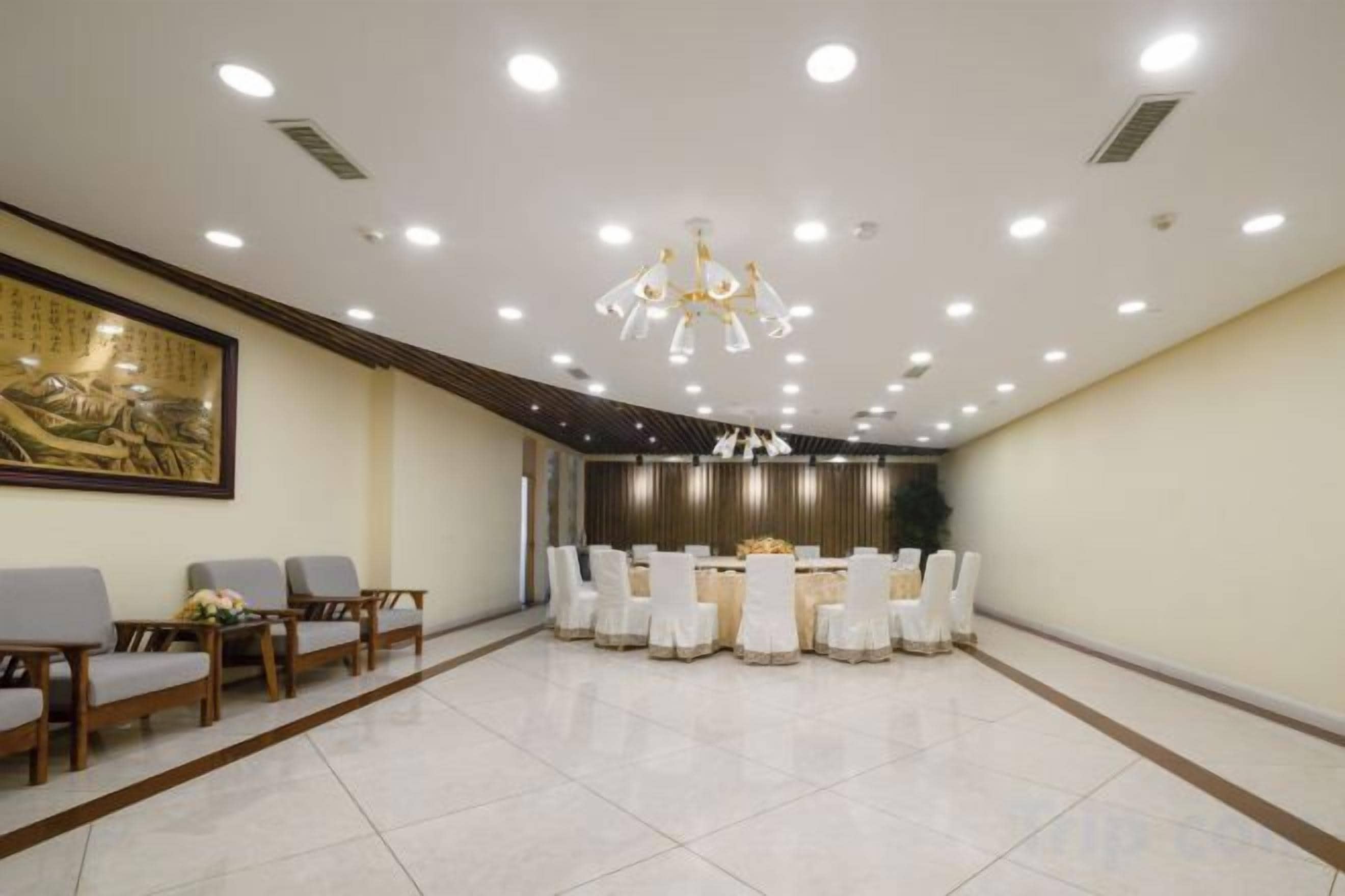 A conference room with a round table, chairs, and a chandelier.