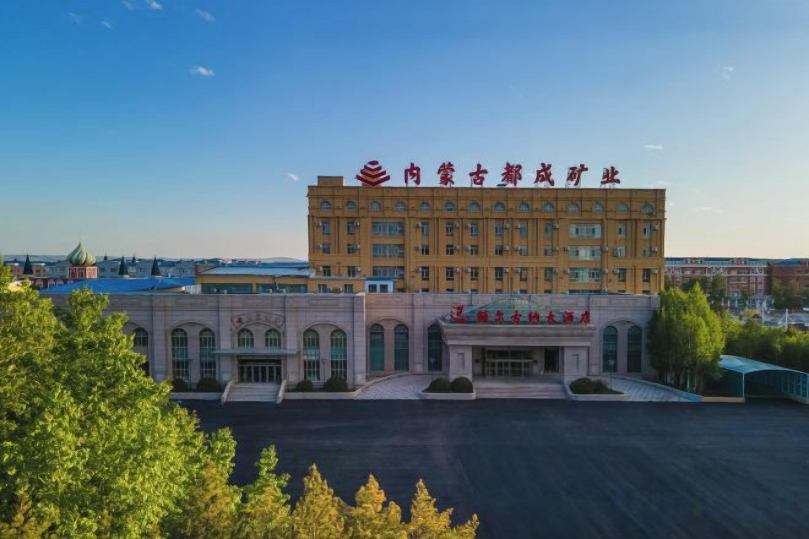 A large building with a prominent entrance and a parking lot in front.