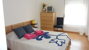 A bedroom with a bed, a dresser, a chair, and a television on a dresser. - Chez Nônô - 4 bedroom, 2 toilet, in the city (Ponta Delgada)