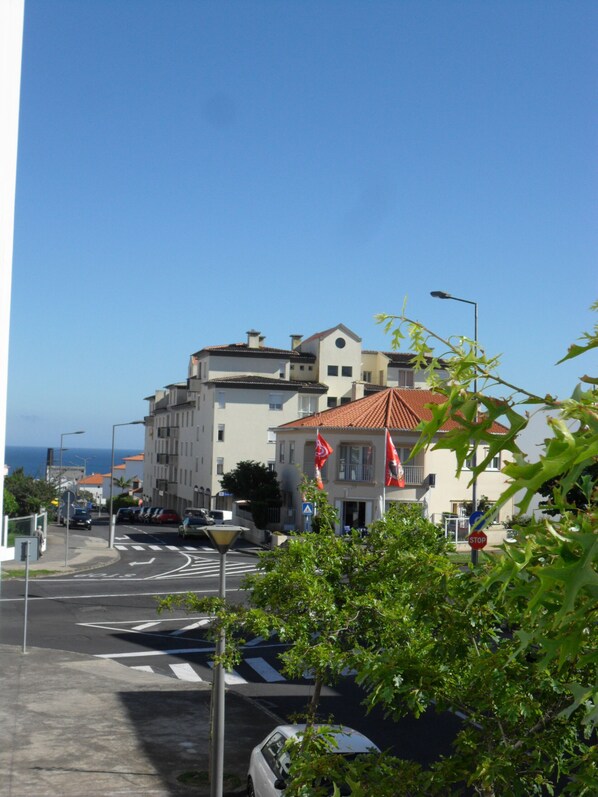 A street view with buildings, cars, and a clear sky. - Chez Nônô - 4 bedroom, 2 toilet, in the city (Ponta Delgada)