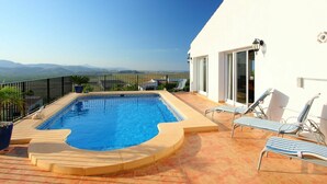 A rooftop pool with a clear view of the mountains, lounge chairs, and a white building with a balcony. - Stunning private villa with WIFI, A/C, private pool, TV, terrace, pets allowed and panoramic view (Pego)