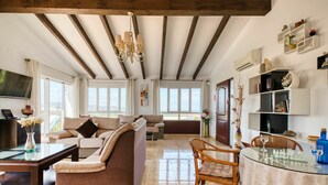 A spacious living area with a high ceiling and exposed wooden beams, furnished with sofas and a glass coffee table. - Stunning private villa with WIFI, A/C, private pool, TV, terrace, pets allowed and panoramic view (Pego)