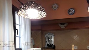 Una cocina con cafetera, una lámpara colgante y un rodillo de papel de cocina en la encimera.