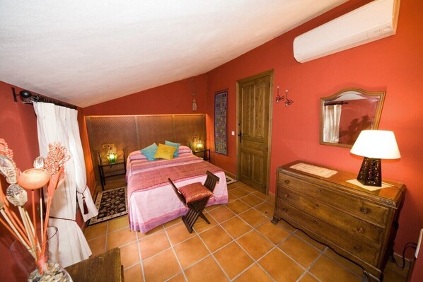 A bedroom with a bed, a dresser, a mirror, and a nightstand.