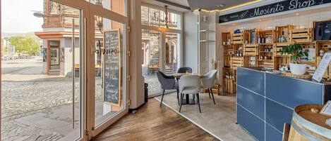 Ein gemütliches Interieur mit einer Kaffeebar, einer Sitzgelegenheit und Blick auf die Straße.