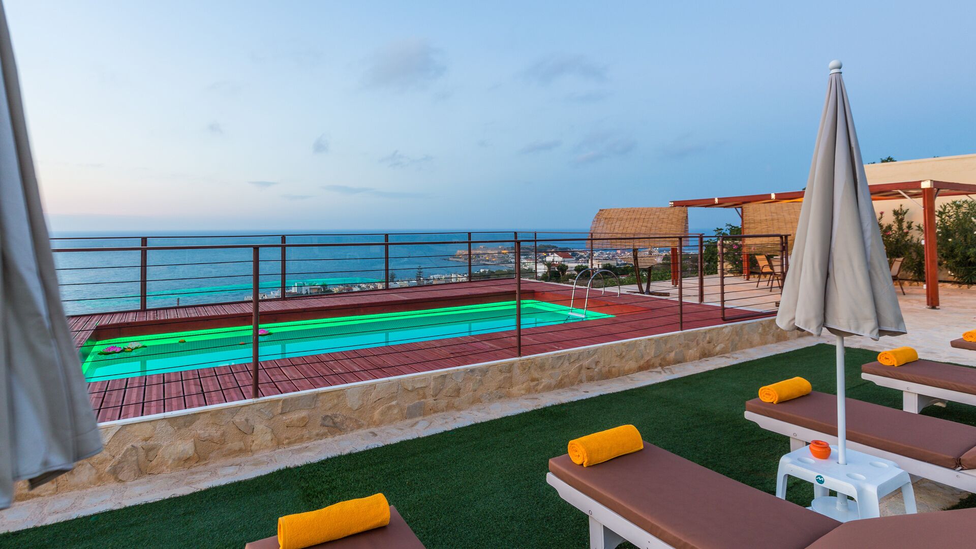 Une piscine sur le toit avec vue sur la mer, des chaises longues et une pergola.