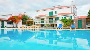 Una piscina al aire libre, sombrillas, tumbonas