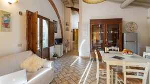 Un interior acogedor con sofá, mesa de comedor y zona de cocina.