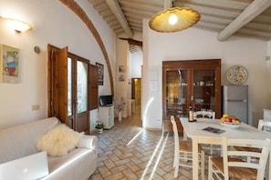 A cozy interior with a sofa, dining table, and kitchen area.