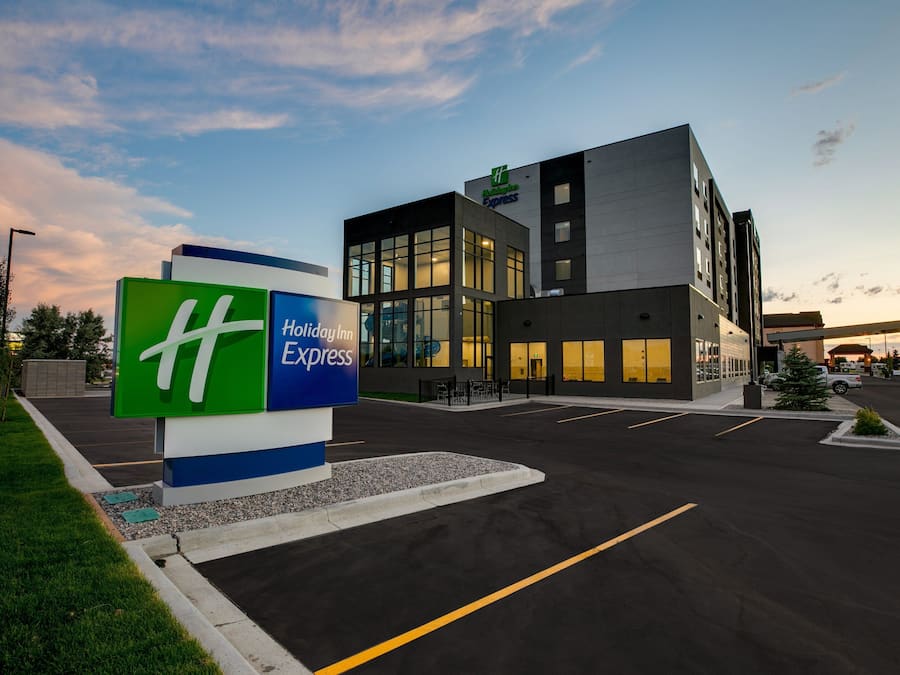 A Holiday Inn Express building with a modern design, large windows, and a parking lot.