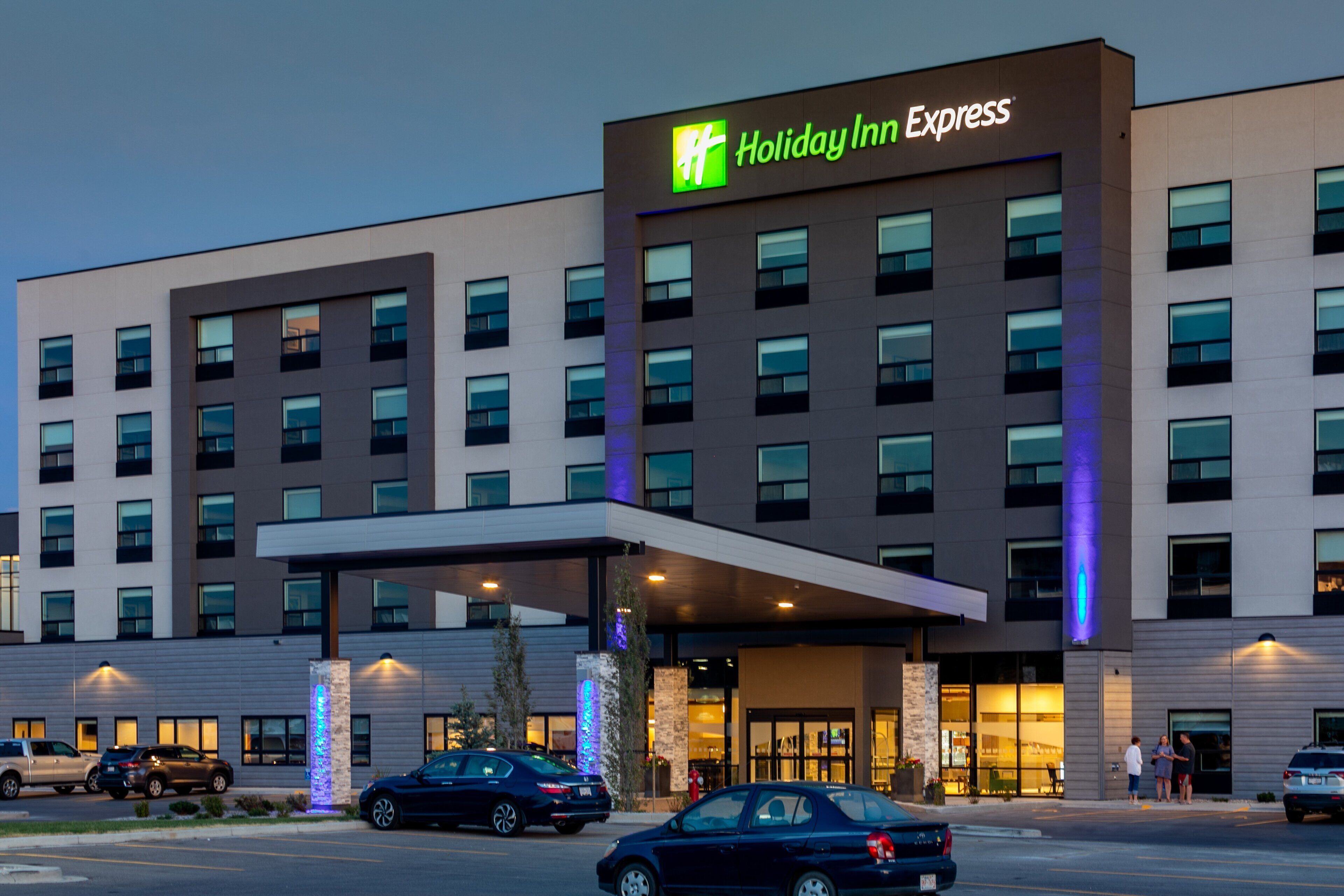 A Holiday Inn Express hotel with a modern facade, multiple windows, and a covered entrance area.