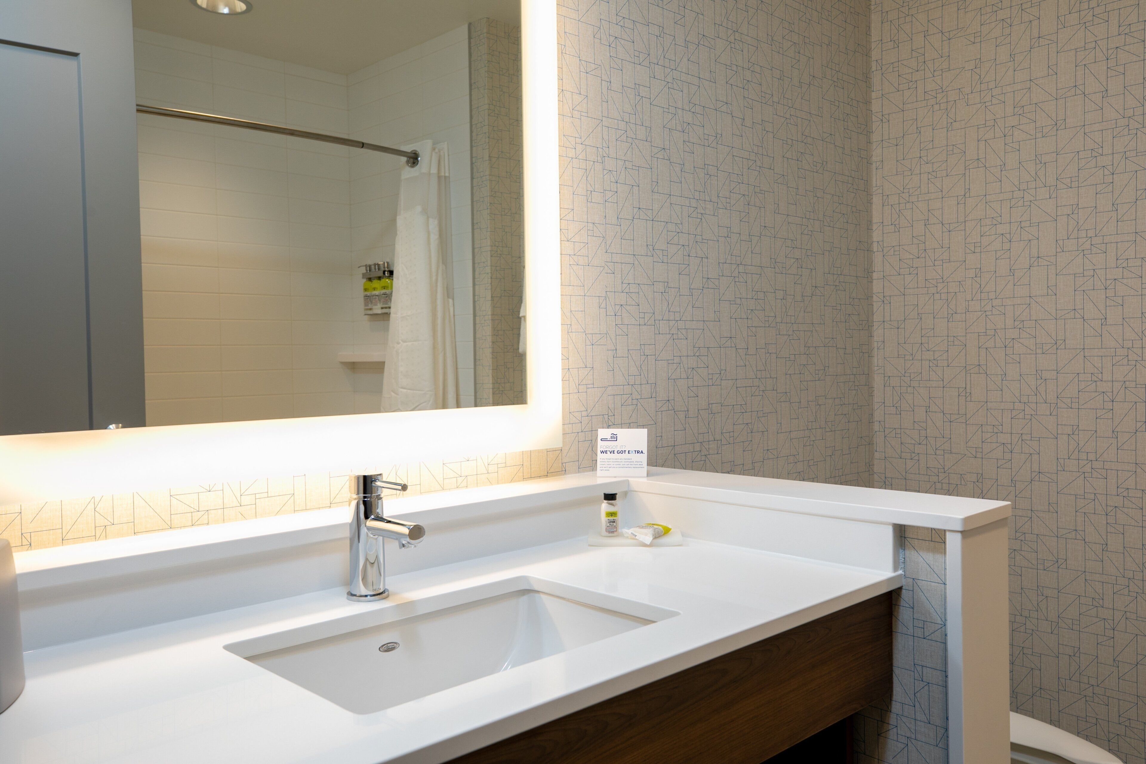 A bathroom with a white sink, a mirror, and a towel rack.