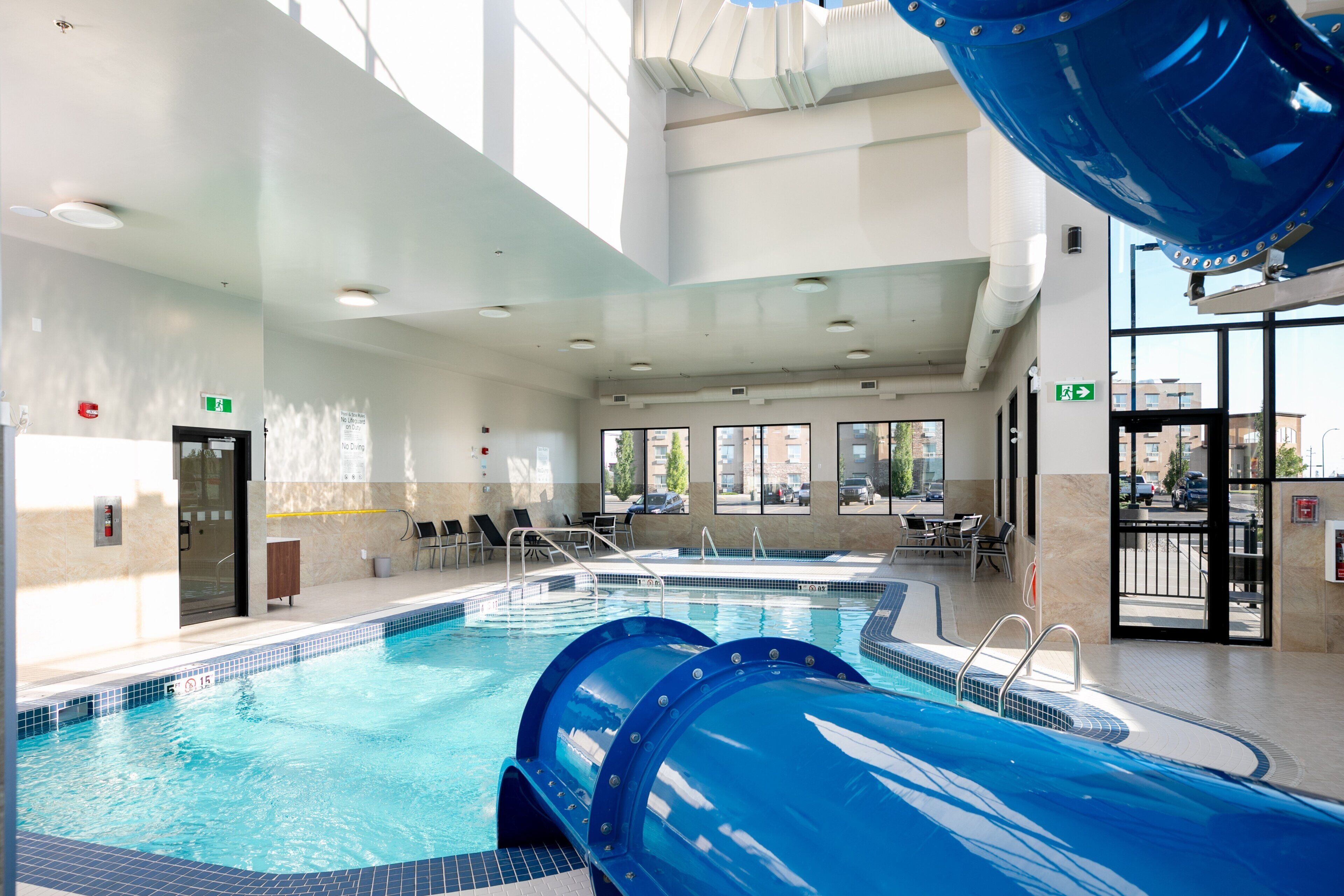 Una piscina techada, sillones reclinables de piscina
