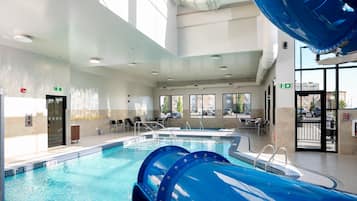 Una piscina techada, sillones reclinables de piscina