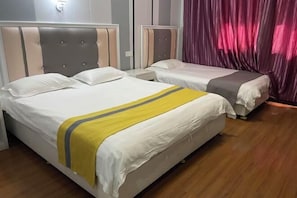 Ein Hotelzimmer mit zwei Betten, jeweils mit Kopfstütze und Nachttisch.