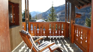 Ein Holzbalkon mit Blick auf schneebedeckte Berge.