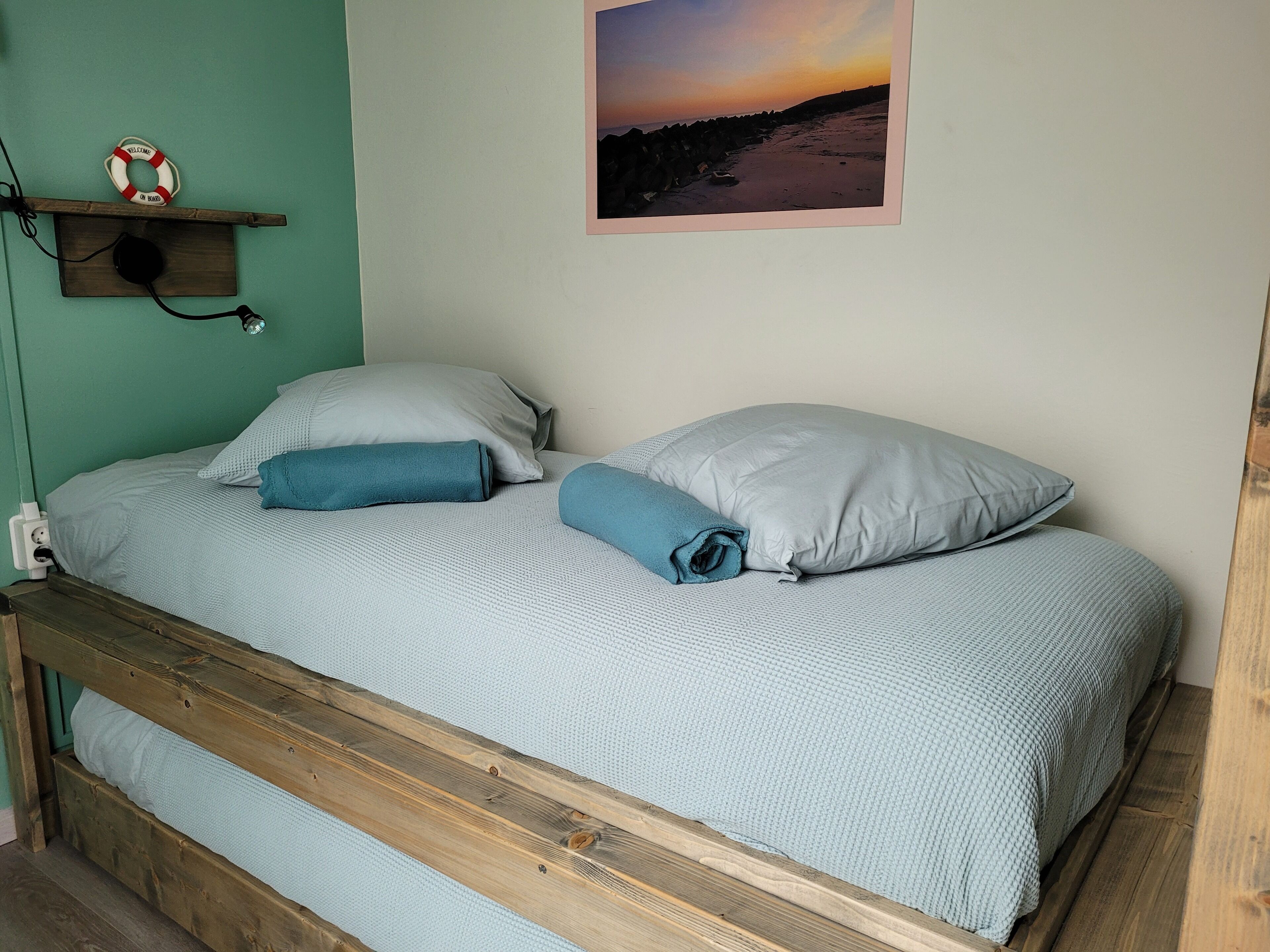 A bed with a wooden frame, two pillows, and a blanket.