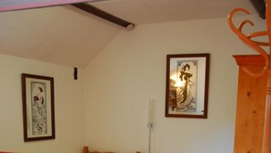 A room with two wooden beds, a red chair, and a wooden cabinet. - Bradley Cross Farm, Shepherds Cottage (Cheddar)