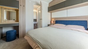 Ein Schlafzimmer mit einem Bett, einem Nachttisch, einem Spiegel und einem Kleiderschrank.