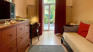Ein Schlafzimmer mit einem Bett, einem Schreibtisch, einem Fernseher und einer Kommode.