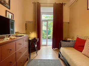 Ein Schlafzimmer mit einem Bett, einem Schreibtisch, einem Fernseher und einer Kommode.