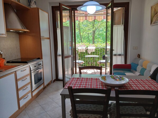 A compact kitchen with a stove, oven, and a dining area with a table and chairs.