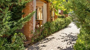 Un bâtiment en pierre doté d’une terrasse en bois et d’un chemin en briques.