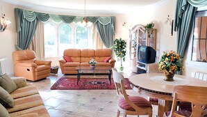 A spacious living room with a sofa, armchairs, a coffee table, and a dining area with chairs and a table. - Stunning private villa for 4 guests with WIFI, A/C, private pool, TV, patio and pets allowed (Benissa)