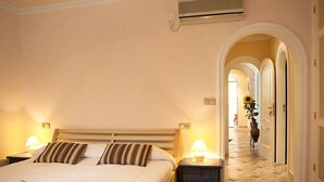 A hotel room with a large bed, bedside lamps, a nightstand, and an air conditioning unit on the wall. - Stunning private villa for 4 guests with WIFI, A/C, private pool, TV, patio and pets allowed (Benissa)