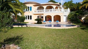 A large, two-story house with a pool, surrounded by palm trees and a well-maintained lawn. - Stunning private villa for 4 guests with WIFI, A/C, private pool, TV, patio and pets allowed (Benissa)