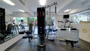 Ein Fitnessstudio mit verschiedenen Trainingsgeräten, darunter Laufbänder und Kraftgeräte.