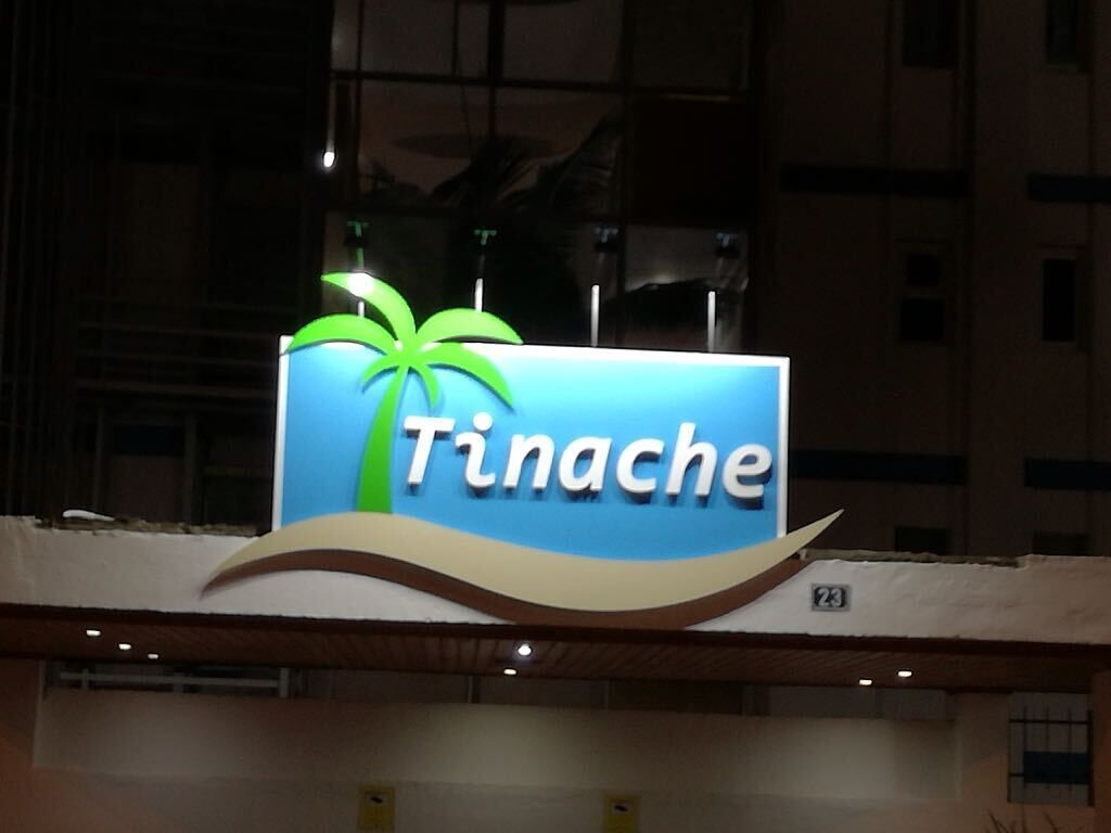 Un letrero con la palabra 'Tinache' y un dibujo de una palmera.