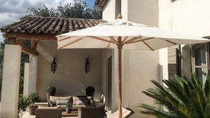 A patio with a white umbrella, lounge chairs, and a sofa. -  BEAUTIFUL FARMHOUSE IN PROVENCE.. (Rognes)