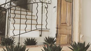 A staircase with a metal railing, a wooden door, and three potted plants on a wooden floor. -  BEAUTIFUL FARMHOUSE IN PROVENCE.. (Rognes)