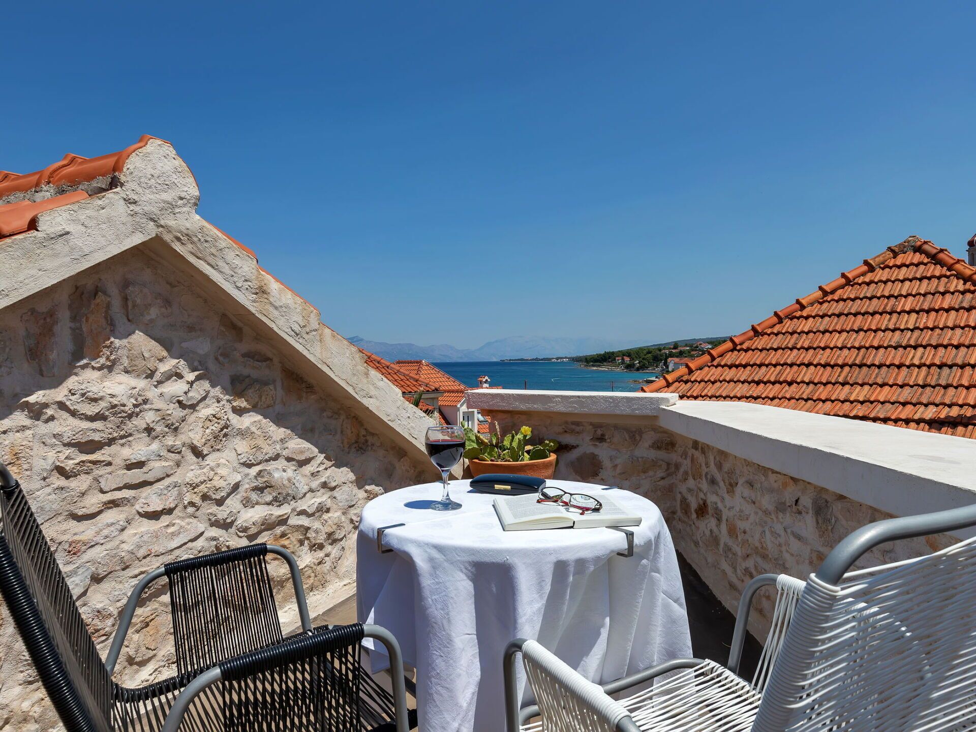 Eine Terrasse mit Tisch für zwei Personen mit Blick auf die Küste.