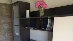 A modern entertainment unit with a TV, shelves, and a cabinet.