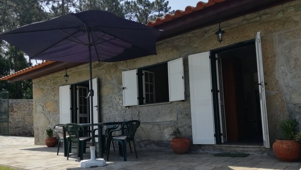 A stone building with a patio area featuring outdoor furniture, a table, and chairs.