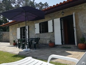 Edificio de piedra con un patio amueblado al aire libre, que incluye una mesa y sillas.