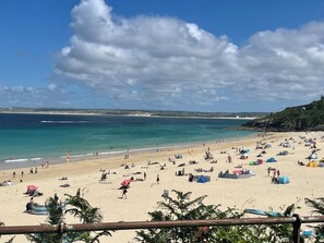 Une plage avec des gens, des tentes et un ciel dégagé.
