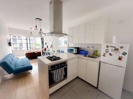 Escritorio, cortinas blackout y tabla de planchar con plancha 