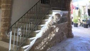 Eine Steintreppe mit einem steinernen Bogen, der zu einer Tür führt.